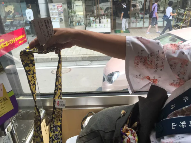 Eine Pilgerin zeigt uns im Bus stolz ihre Stempel vom Pilgerweg in Shikoko