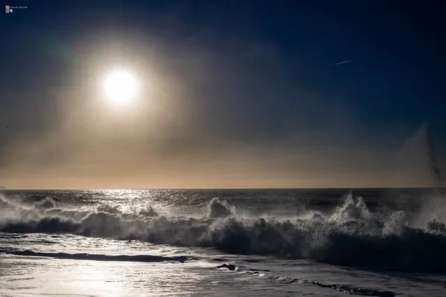 Das Wasser weicht und die Sonne spiegelt sich am nassen Strand