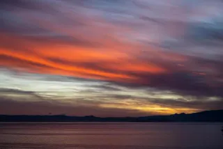 Evening sky over the Tasmanian sea – flowing shades of red, violet and blue symbolizing connectedness and transition.
